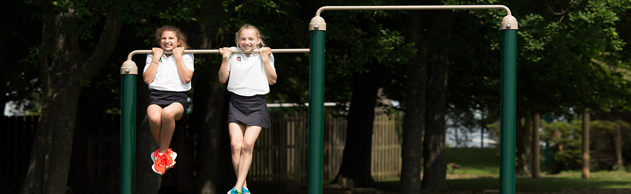 girls using fresh air fitness outdoor gym